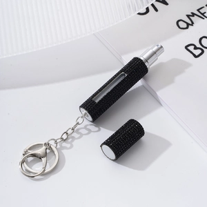 Detail of black rhinestone portable perfume bottle with metal keychain and spray nozzle