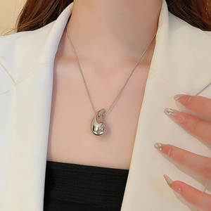 Close-up of a silver resin flower pendant necklace on model showing minimalist bean style