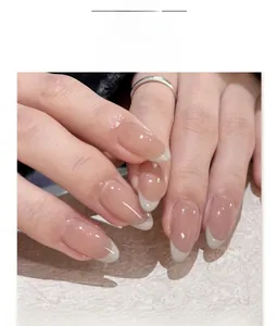 Macro shot of French white tip almond fake nails on hands with a pink nude base color