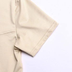 Close-up of the beige knit fabric texture and sleeve stitching on the slim bodysuit