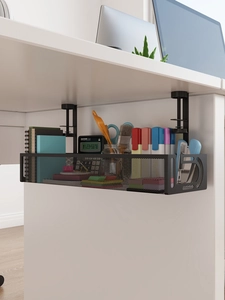 Close-up of black metal wire mesh cable management tray installed under a white office desk