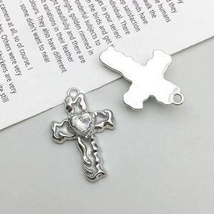 Macro detail of silver alloy cross pendants with lava texture and heart crystal