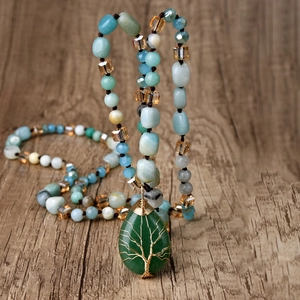 Long beaded necklace featuring a green aventurine drop pendant with tree of life wire wrap