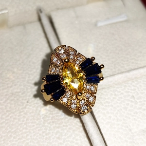 Macro shot of 18K gold plated ring with yellow zircon and baguette sapphire accents