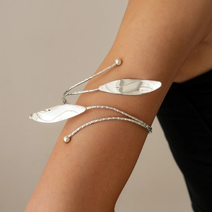 Detail of silver spiral leaf arm cuff with dual-layer wrap and textured metal finish