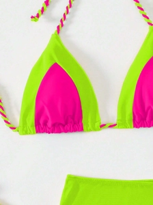 Detail view of contrast neon green and hot pink bikini with twisted tie rope strings