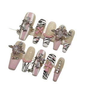 Handmade pink zebra pattern press-on nails with silver cross and saturn charms