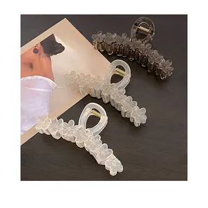 Detailed view of three jelly-colored flower hair claws in gray and translucent white matte