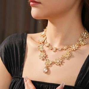 Détail du collier vintage doré avec papillon en diamant et perle porté par un mannequin