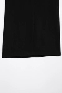 Vue détaillée de l'ourlet de la robe en velours noir avec texture de tissu fine
