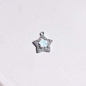 Macro detail of star-shaped silver pendant with sparkling crystals and iridescent stone