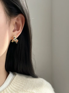 Detail of colorful gemstone stud earrings on model with gold plating and zircons