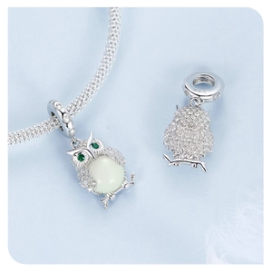 Macro detail of S925 sterling silver owl pendant with luminous stone and zircon inlays