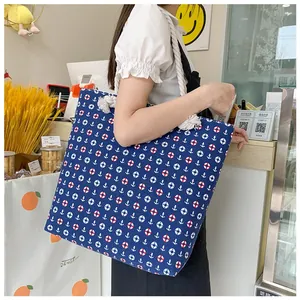 Detail of large canvas tote with nautical anchor print and thick cotton rope handles