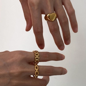 Three gold vintage chain rings with heart design shown on hands against a neutral background
