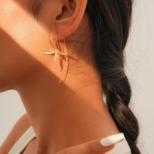 Close-up of elegant gold iris flower earrings worn by a model for a vintage look