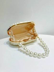 Details der weißen Abendtasche aus Satin mit Perlengriff und goldenem Verschluss