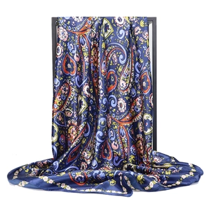 Blue paisley silk scarf 90x90cm with vibrant floral print on professional display