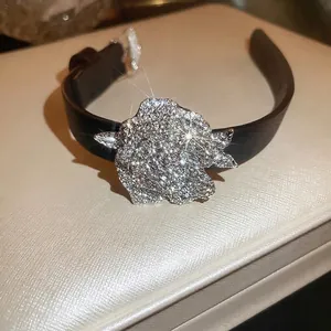 Funkelndes Strass-Blumen-Lederarmband mit silbernen Akzenten auf weißem strukturiertem Stand