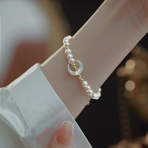 Detail of 14K gold plated baroque pearl bracelet with a shell crescent moon charm