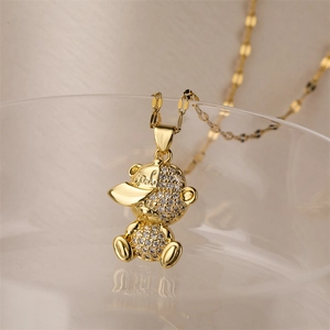 Détail macro d'un pendentif ours doré portant un bonnet COOL avec des cristaux brillants