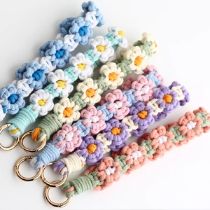 Detailed macro of handmade crochet daisy wristlets with vibrant colors and gold metal rings