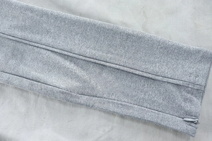 Detail of grey knitted fabric texture and seamless invisible zipper on yoga jacket