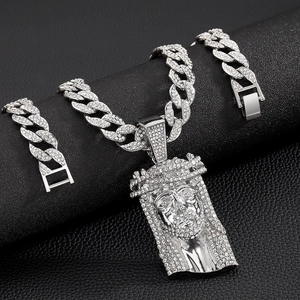 Close-up of silver Cuban link chain and Jesus head pendant with sparkling rhinestones