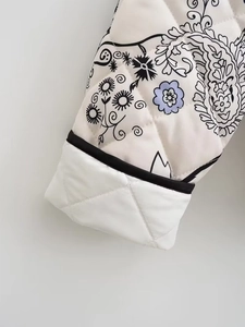Close-up of quilted floral sleeve detail on the cream paisley cotton padded jacket