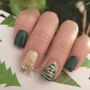 Nahaufnahme von dunkelgrünen und goldenen Glitzer-Kunstnägeln mit festlichem Tannenbaum-Design