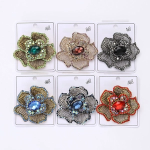 Detail view of vintage flower brooches with rhinestones in six assorted colors