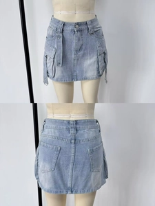 Detail of light blue denim cargo mini skirt with large pockets and washed finish