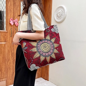Vintage embroidered canvas tote bag with floral patterns and striped shoulder straps