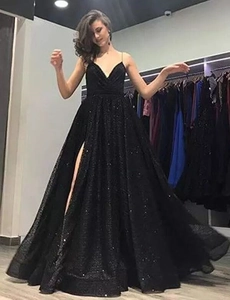 Detail of black sequin evening gown featuring a deep V-neck and delicate spaghetti straps