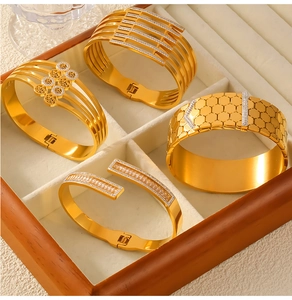 Detailed close-up of four gold-plated titanium steel bracelets with hollow and crystal inlay