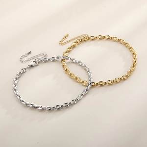 Close-up of gold and silver geometric titanium steel anklets with lobster clasps