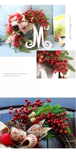 Close-up of Christmas wreath with red berries, pine cones, and a white wooden letter M