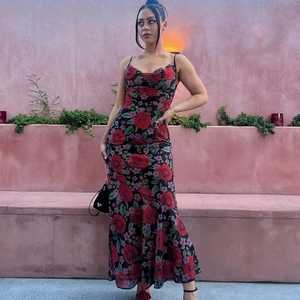 Détail de l'imprimé floral rose rouge sur une robe longue d'été ajustée en noir