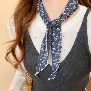 Detailed close-up of navy blue floral scarf with elegant white scalloped edge finish