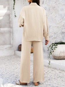 Rear view of beige textured two-piece set featuring shirt and wide-leg trousers on model