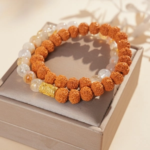 Detail view of Bodhi seed and white crystal beads with engraved matte gold metal spacers