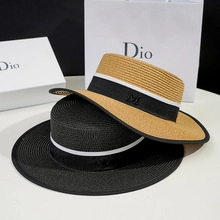 Detail of wide-brim boater hat featuring fine straw weave and M letter embroidery
