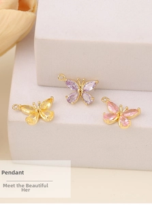 Detailed view of butterfly pendants with purple, yellow, and pink pear-cut zircons