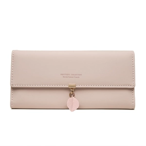 Detail of light pink PU leather wallet featuring a gold metal leaf pendant and flap closure