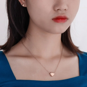 Primo piano di un set di gioielli a cuore placcati oro 14k indossati da una modella
