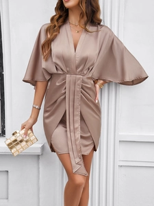 Detail of khaki satin dress featuring deep V-neck, kimono sleeves and elegant draping