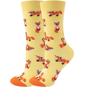 Detail of yellow mid-calf socks featuring a fox pattern with orange toes and heels