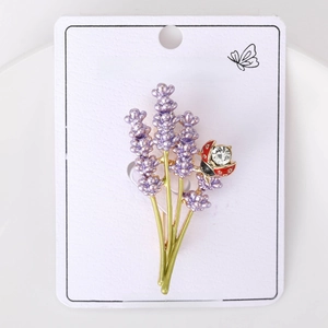 Macro detail of lavender sprigs with red crystal ladybug brooch on fashion card