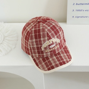 Detail of red and white plaid tweed baseball cap with embroidered lettering and piping