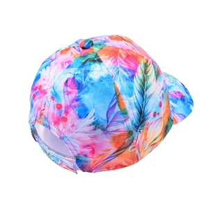 Macro detail of colorful tie-dye baseball cap featuring vibrant feather and floral patterns